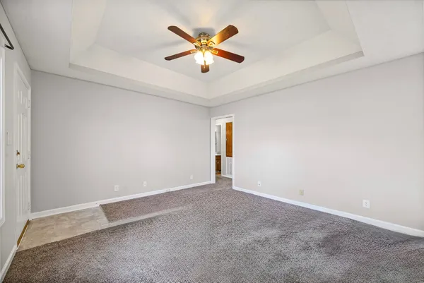 an empty room with ceiling fan and window