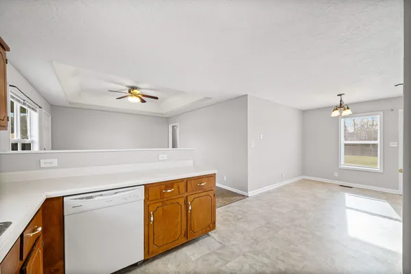 an empty room with a window and a fan