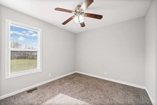 a view of a livingroom with a ceiling fan and window