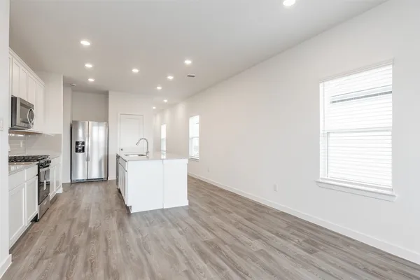 a view of a kitchen with wooden floor and electronic appliances