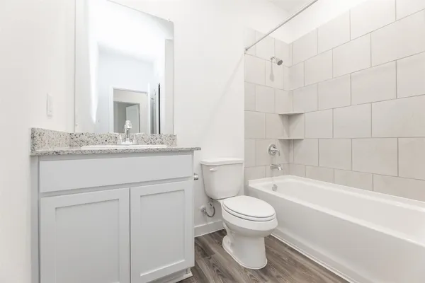 a bathroom with a granite countertop toilet a sink and bathtub