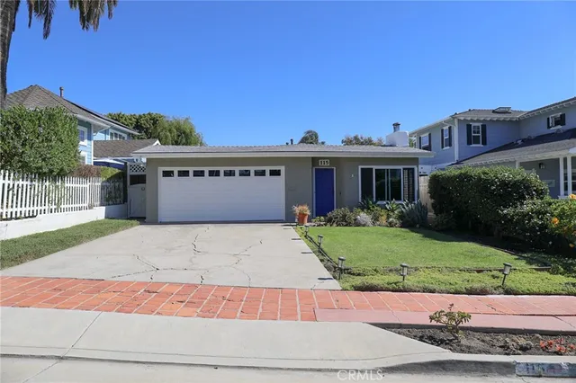 a front view of a house with a yard and a garage
