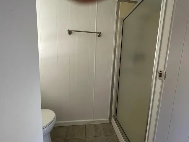 a bathroom with a granite countertop toilet and a shower