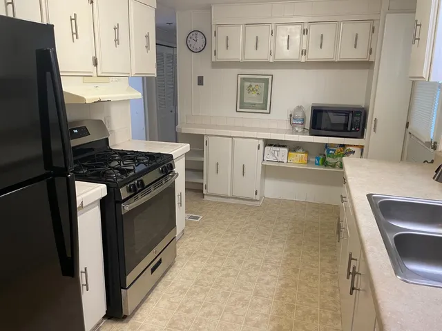 a kitchen with stainless steel appliances granite countertop a stove a sink and a refrigerator