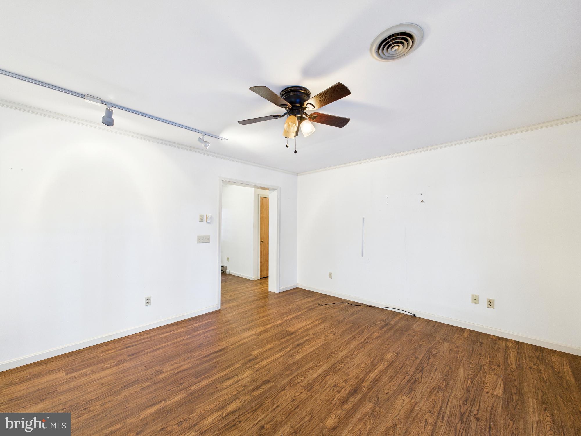 5046 Manokin Road Crisfield, MD 21817 - Photo 13 of 72 a view of a big room with wooden floor and a ceiling fan