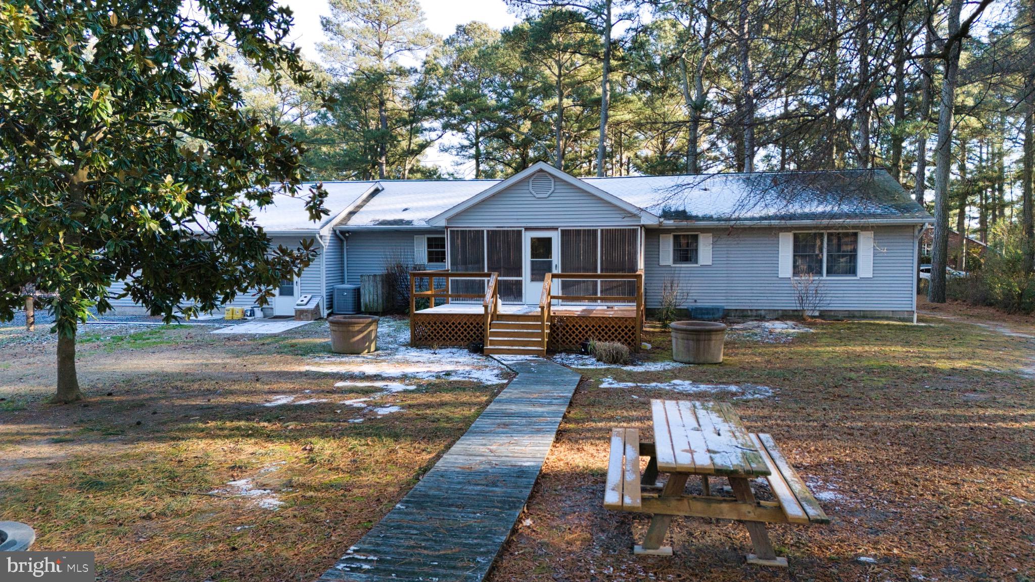 5046 Manokin Road Crisfield, MD 21817 - Photo 59 of 72 a front view of a house with yard fire pit table and chairs