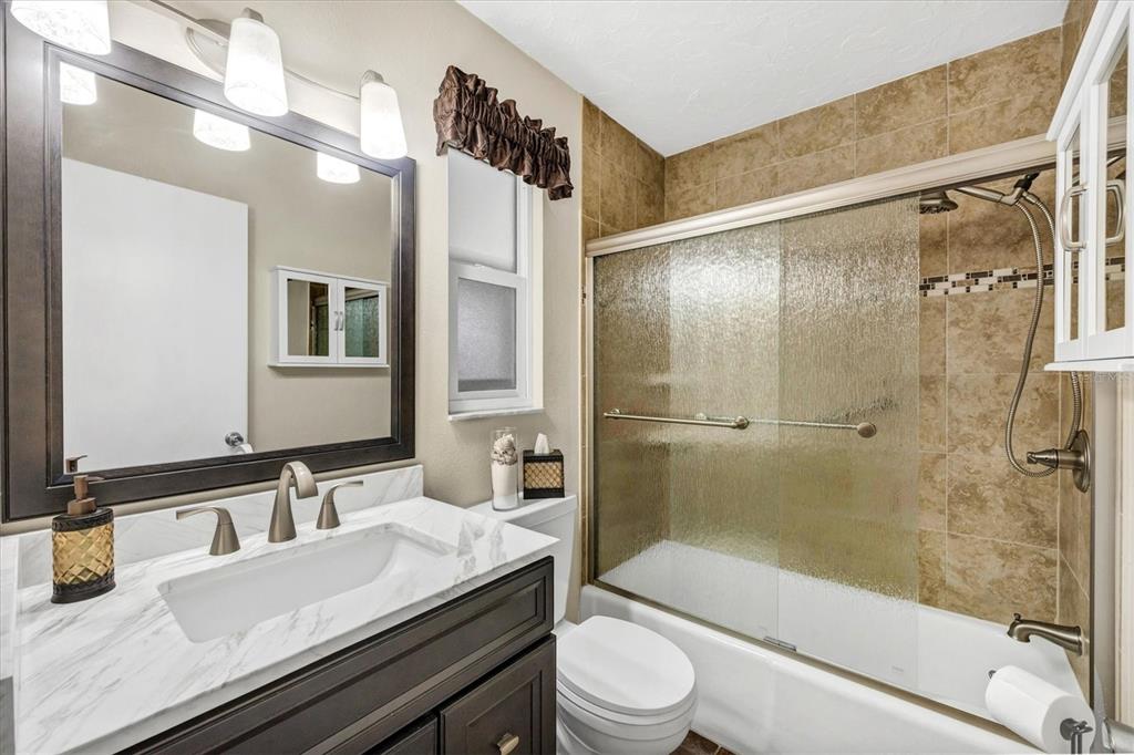 6416 Mercer Road Bradenton, FL 34207 - Photo 18 of 38 a bathroom with a granite countertop sink toilet and shower