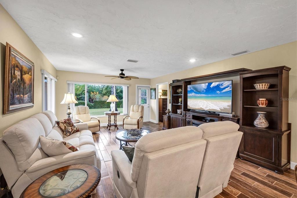 6416 Mercer Road Bradenton, FL 34207 - Photo 7 of 38 a living room with furniture a flat screen tv and a large window
