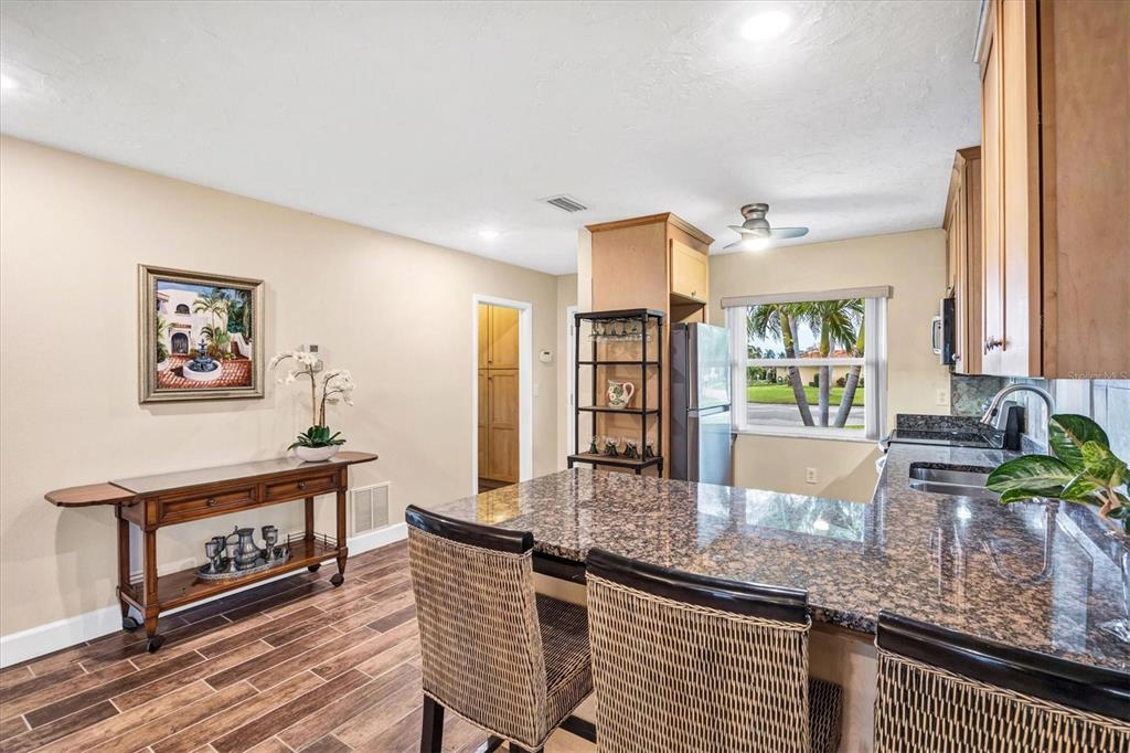 6416 Mercer Road Bradenton, FL 34207 - Photo 10 of 38 a kitchen with granite countertop a stove a sink and a wooden cabinets