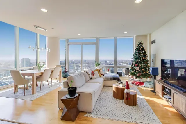 a living room with furniture large window and wooden floor