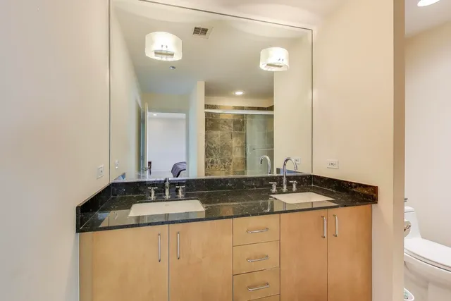 a bathroom with a granite countertop sink and a mirror