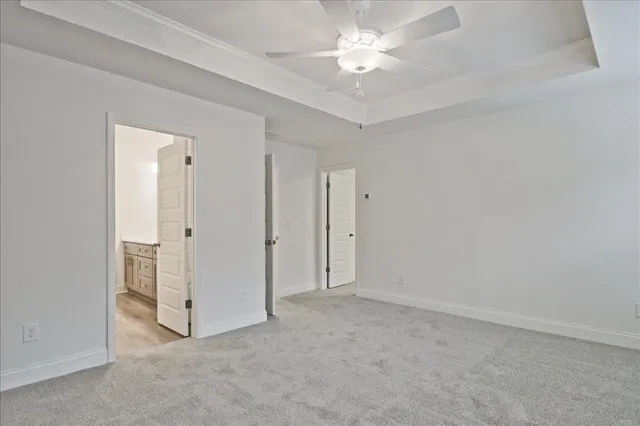 an empty room with closet and a ceiling fan