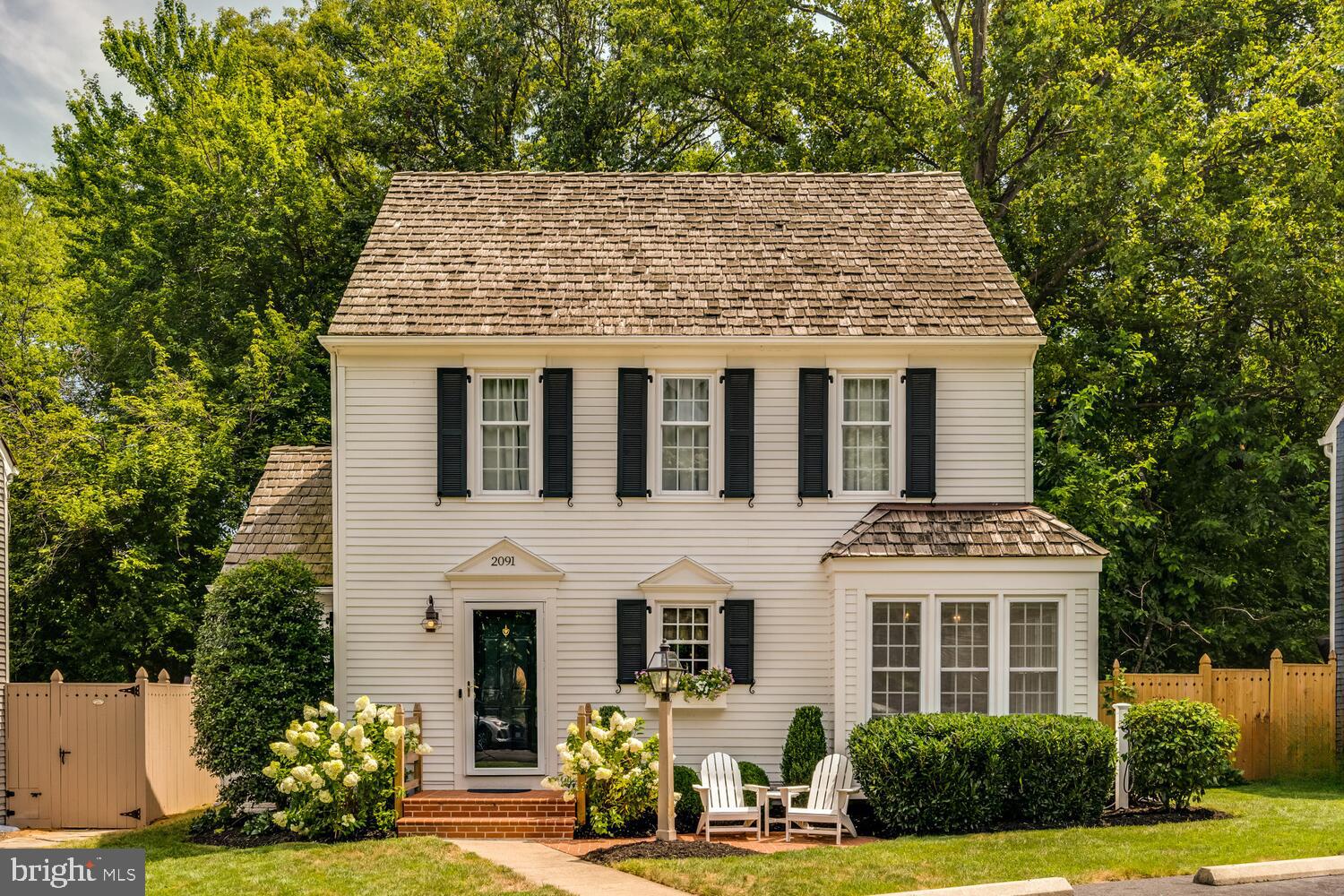 2091 Cobblestone Lane Reston, VA 20191 - Photo 1 of 33 a view of a white house with large windows and a lawn chairs