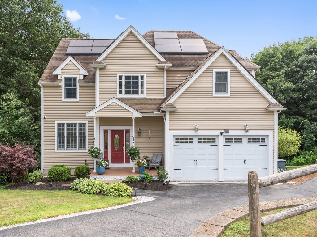 a view of a white house with large windows and plants
