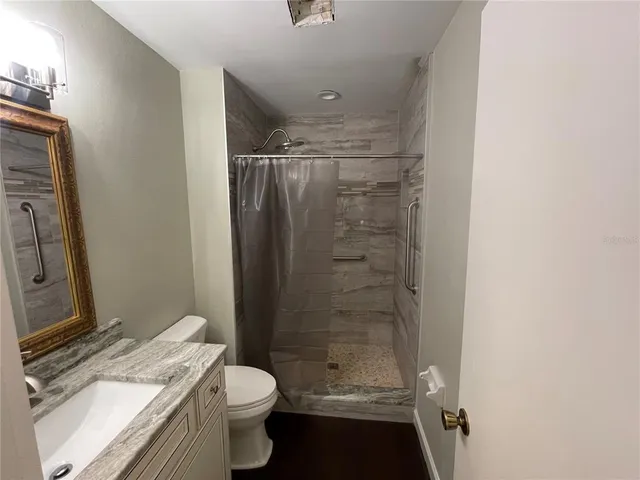 a bathroom with a granite countertop sink toilet and shower