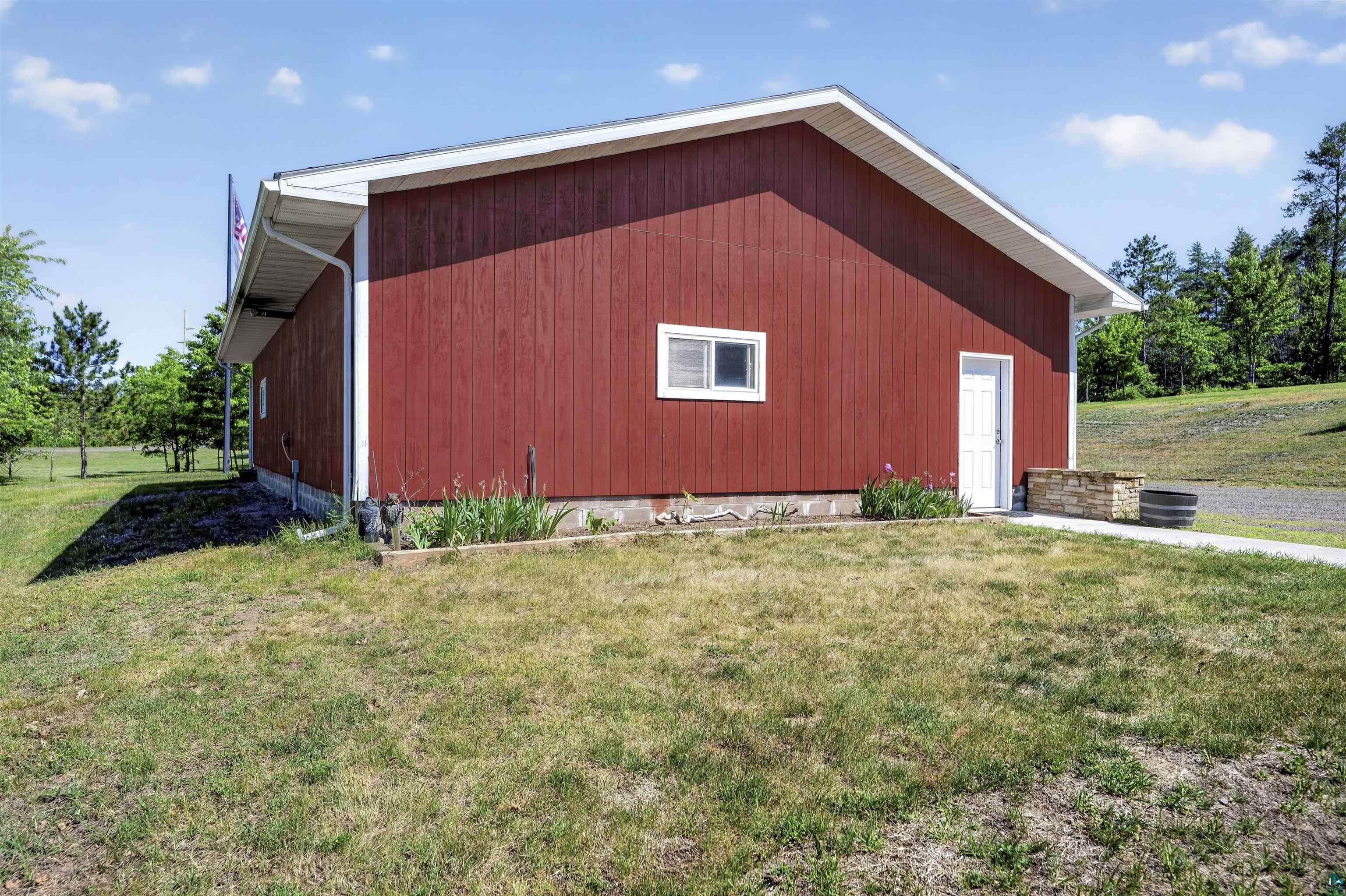 11702 East Mail Road Gordon, WI 54838 - Photo 30 of 60 Red-painted exterior featuring vertical siding, white trim, and a white entry door