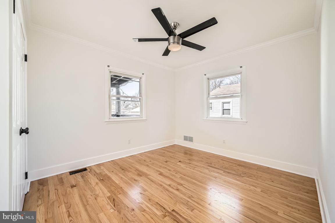 317 Townsend Road Essex, MD 21221 - Photo 11 of 28 an empty room with wooden floor and windows