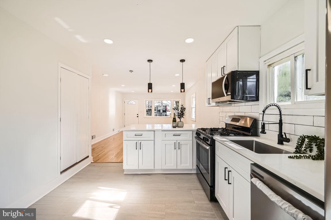 317 Townsend Road Essex, MD 21221 - Photo 10 of 28 a kitchen with stainless steel appliances kitchen island granite countertop a sink stove top oven and refrigerator