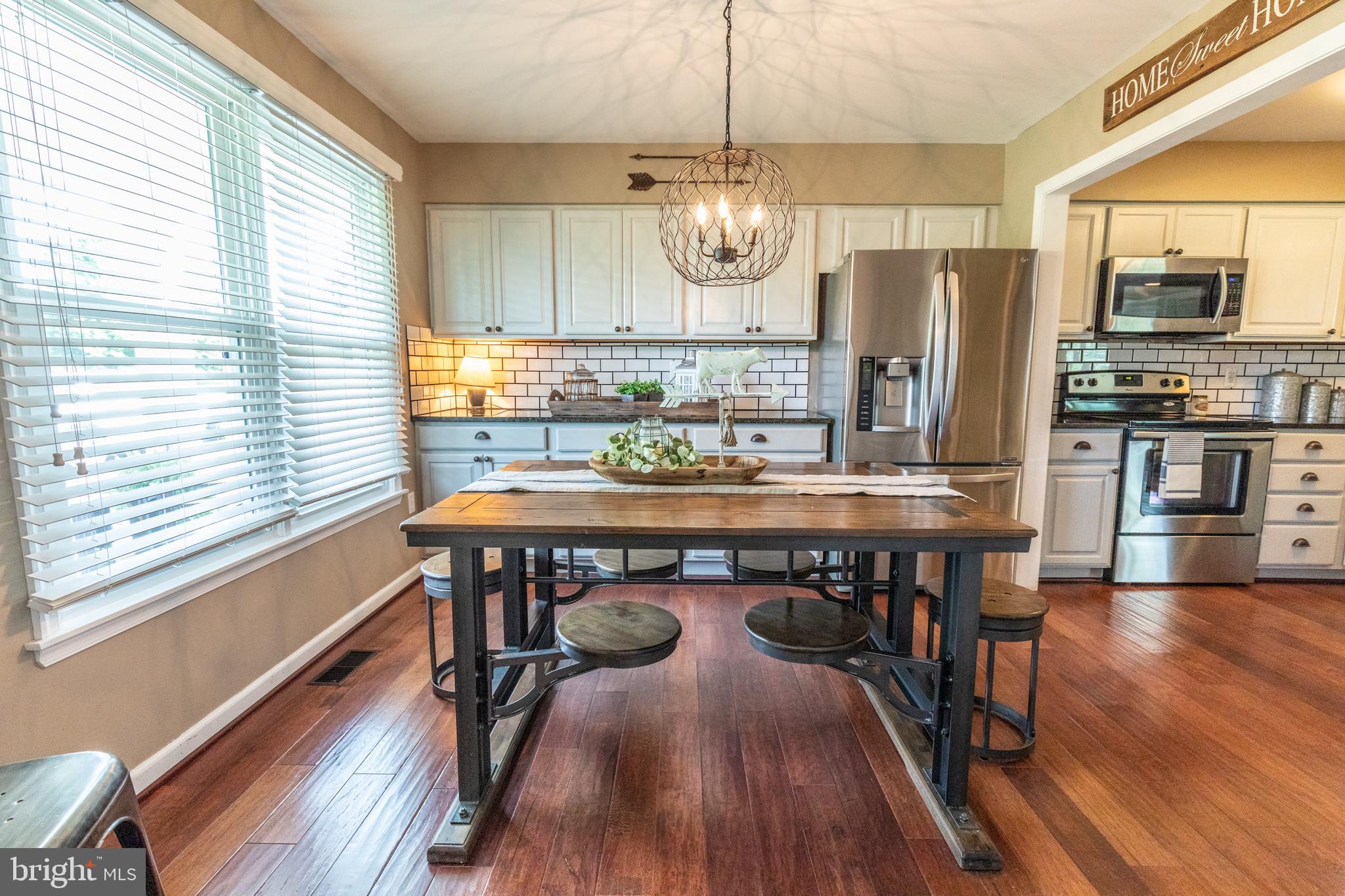 193 Quail Run Road Summit Point, WV 25446 - Photo 20 of 72 a kitchen with stainless steel appliances granite countertop a kitchen island hardwood floor a dining table and chairs
