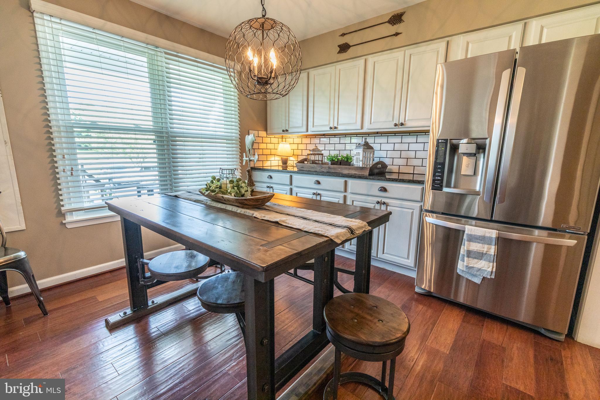 193 Quail Run Road Summit Point, WV 25446 - Photo 22 of 72 a kitchen with stainless steel appliances a table chairs and a refrigerator