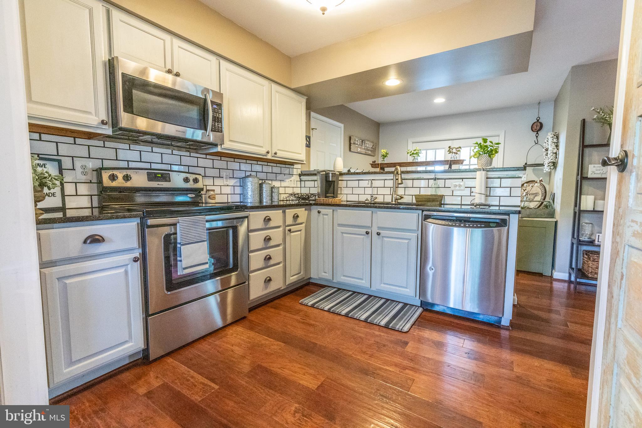 193 Quail Run Road Summit Point, WV 25446 - Photo 24 of 72 a kitchen with stainless steel appliances granite countertop a stove a sink dishwasher and a refrigerator