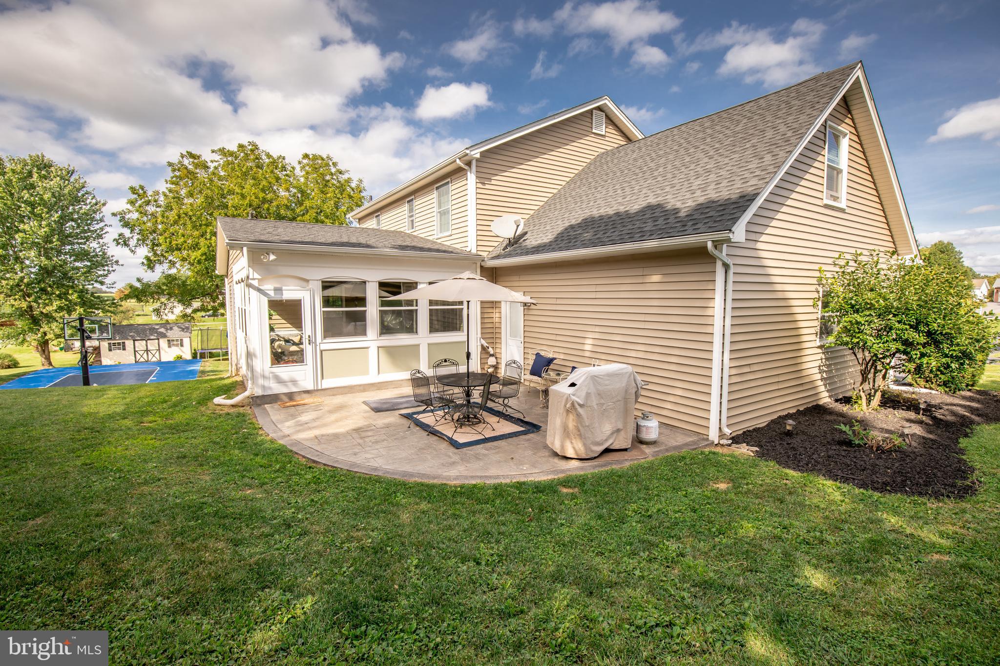193 Quail Run Road Summit Point, WV 25446 - Photo 6 of 72 a view of a backyard with table and chairs and a large tree