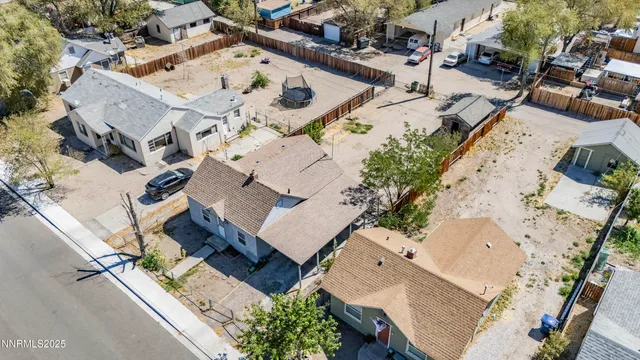 an aerial view of a house with a yard and large trees