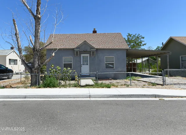 a front view of a house with a yard and potted plants
