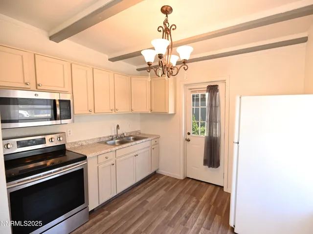 a kitchen with stainless steel appliances a stove a microwave and white cabinets