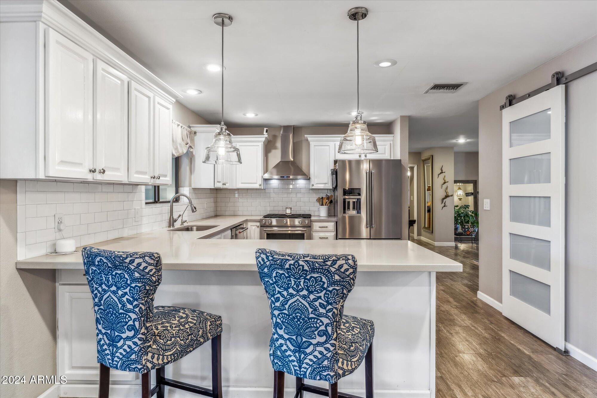 8019 North 7th Avenue Phoenix, AZ 85021 - Photo 11 of 43 a kitchen with stainless steel appliances granite countertop a refrigerator a stove a sink dishwasher with a dining table and chairs