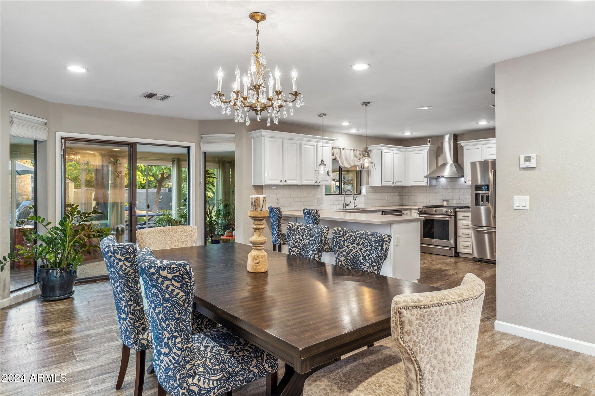 8019 North 7th Avenue Phoenix, AZ 85021 - Photo 14 of 43 a view of a dining room and livingroom with furniture wooden floor and a chandelier