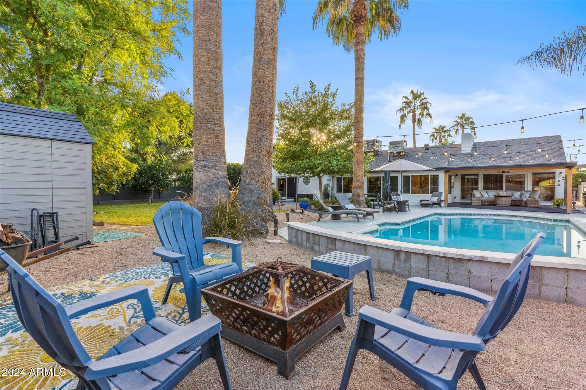 8019 North 7th Avenue Phoenix, AZ 85021 - Photo 36 of 43 a view of a patio with couches table and chairs under an umbrella with potted plants