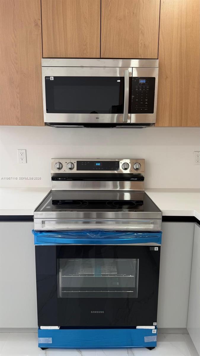 9620 Southwest 9th Terrace Miami, FL 33174 - Photo 13 of 26 a kitchen with stainless steel appliances a stove a microwave a sink and cabinets