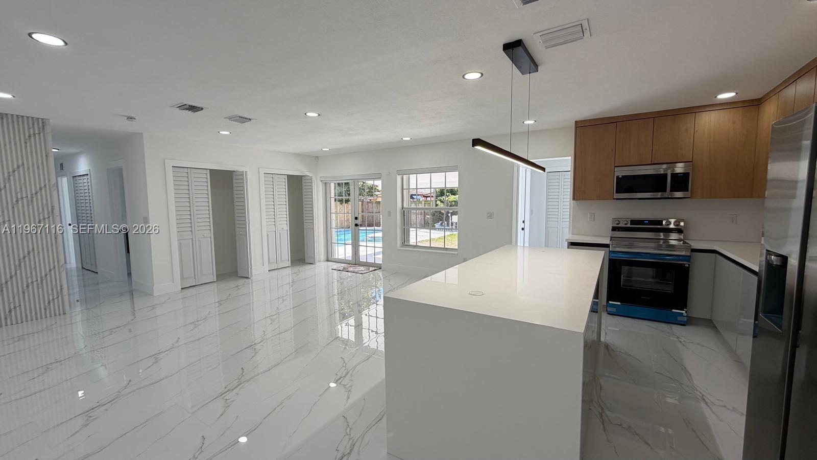 9620 Southwest 9th Terrace Miami, FL 33174 - Photo 18 of 26 a kitchen with stainless steel appliances kitchen island granite countertop a refrigerator a sink a stove and oven with wooden floor