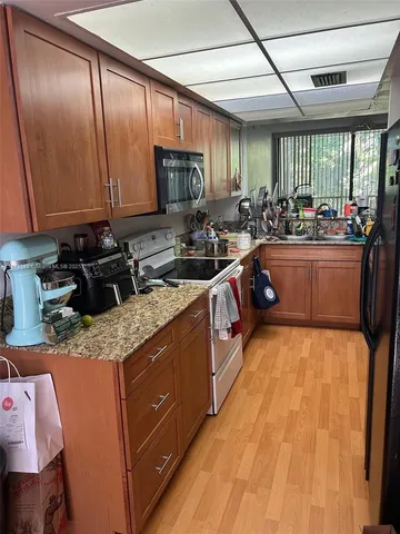 a kitchen with stainless steel appliances granite countertop a sink stove and cabinets