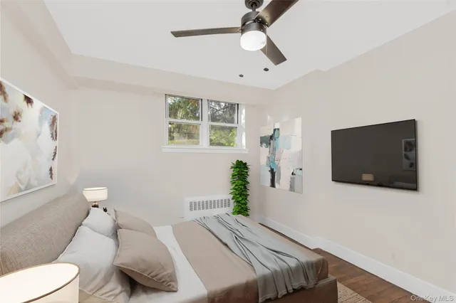 a bedroom with a bed window and a flat screen tv