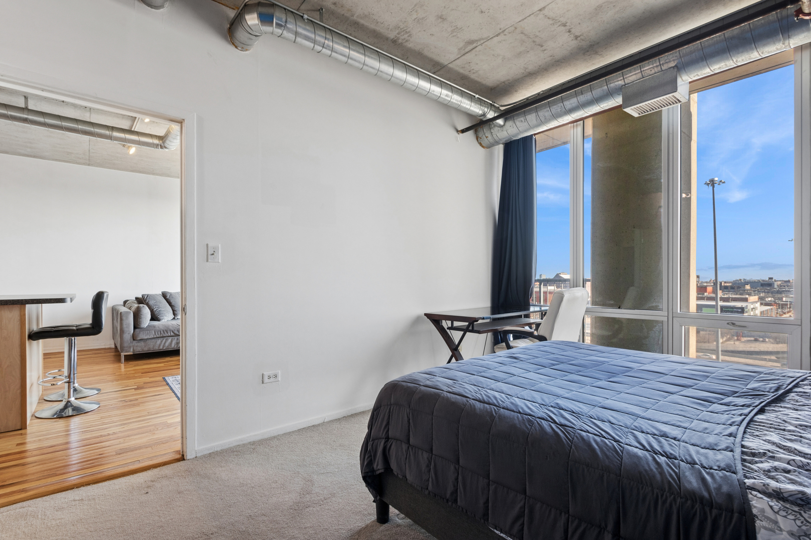 700 West Van Buren Street, Unit 1105 Chicago, IL 60607 - Photo 13 of 19 a bedroom with a bed and a mirror