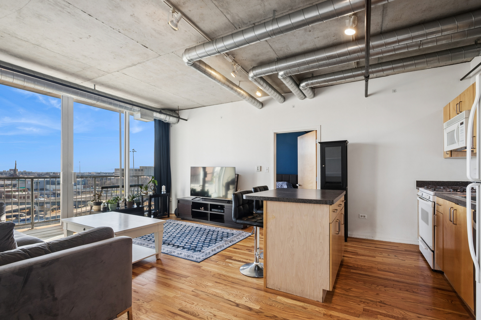 700 West Van Buren Street, Unit 1105 Chicago, IL 60607 - Photo 5 of 19 a living room with furniture and a floor to ceiling window