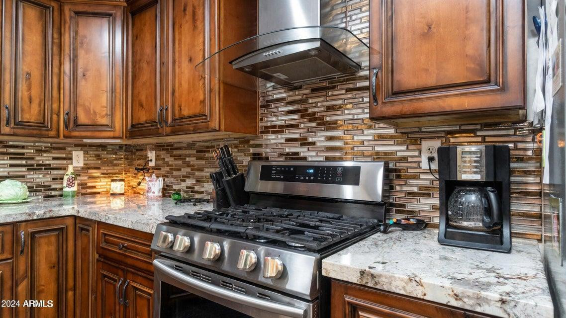 1011 West Northern Avenue Phoenix, AZ 85021 - Photo 7 of 25 a kitchen with wooden cabinets and a stove top oven