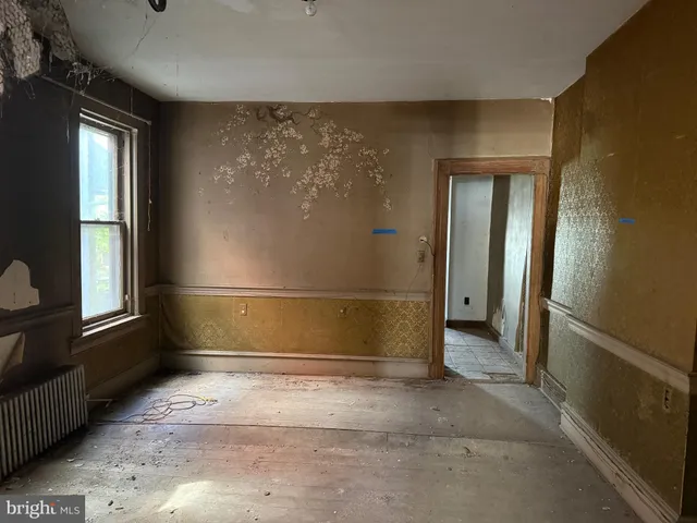 a view of a hallway with wooden floor and a bathroom