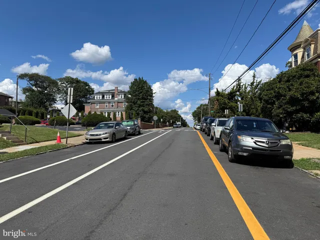 a view of a city street with a car parked on the road