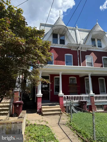 a view of a brick house with large windows and a table and chairs