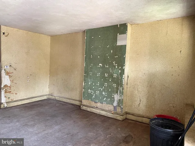 a view of an empty room with a fireplace and a window