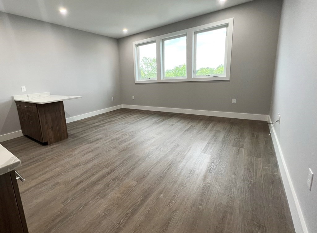 80 Bridge Street, Unit 308 Dedham, MA 02026 - Photo 11 of 19 an empty room with wooden floor and windows