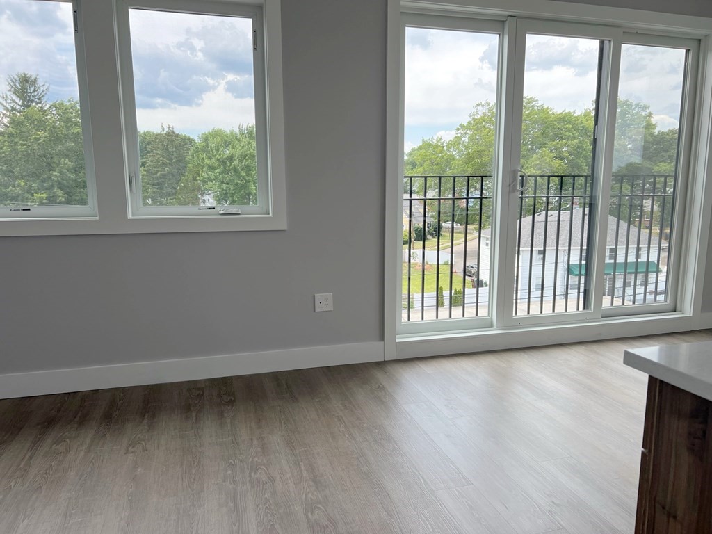 80 Bridge Street, Unit 308 Dedham, MA 02026 - Photo 8 of 19 a view of an empty room with wooden floor and a window