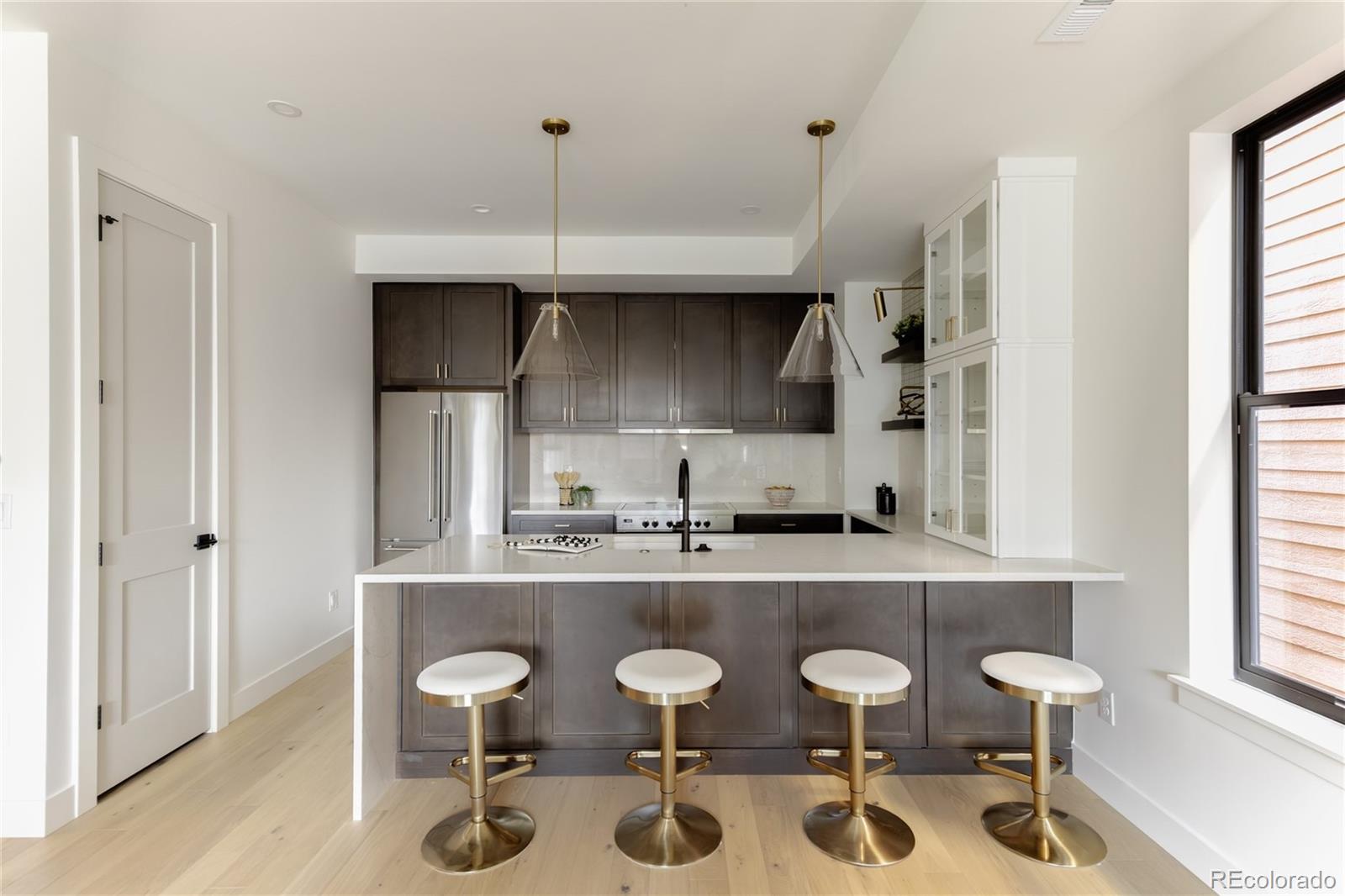1749 North Williams Street, Unit 2 Denver, CO 80218 - Photo 8 of 34 a kitchen with stainless steel appliances a dining table chairs and a large window