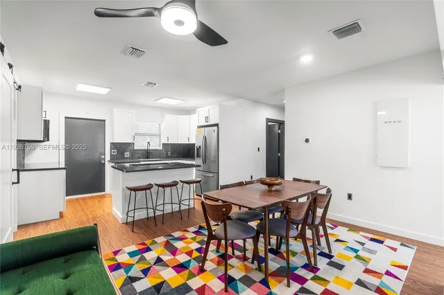 a kitchen with stainless steel appliances kitchen island granite countertop a dining table and chairs