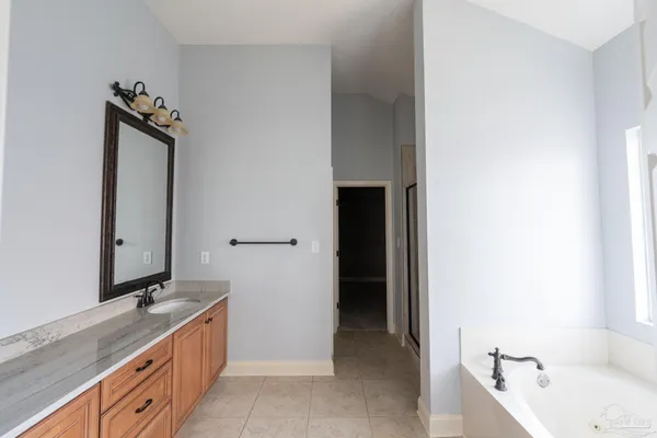 a bathroom with a tub sink and mirror