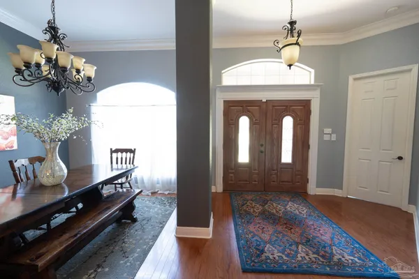 a hallway with dining room and chandelier