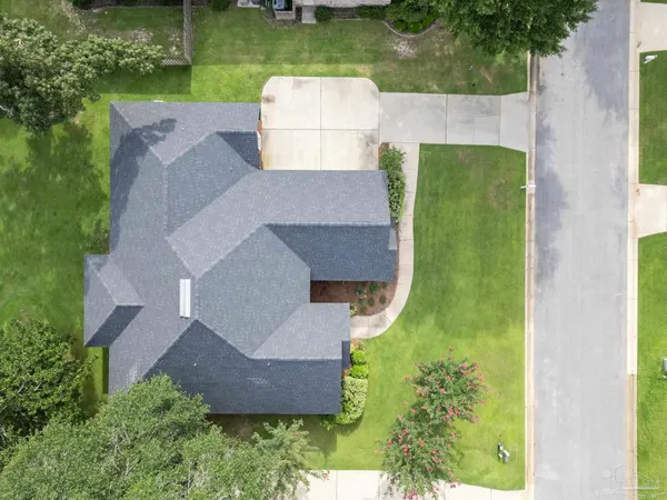 an aerial view of a house with garden space and a swimming pool